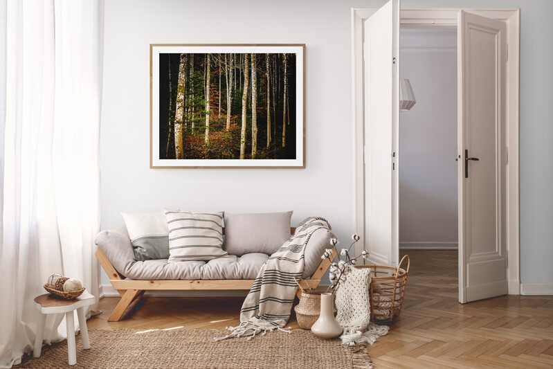 oak-framed image of a forest scene in a neutral tone living room setting
